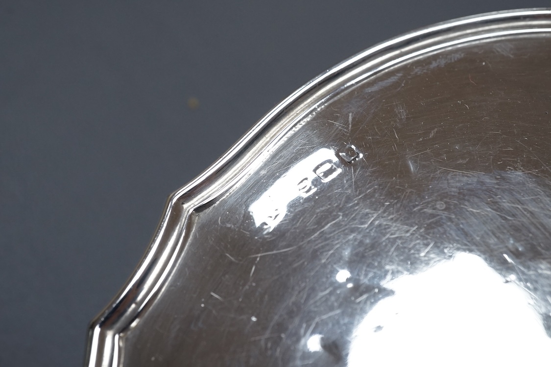 A George V silver mounted hand mirror, a silver spoons and pusher, a silver christening fork and spoon and a silver plated tea caddy.